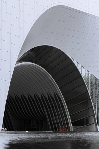 这座建筑是白色的大型建筑 具有现代建筑风格 并在水中有一艘船。