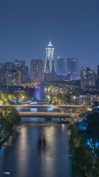 夜晚的城市 建筑物被点亮 河上有一座桥。