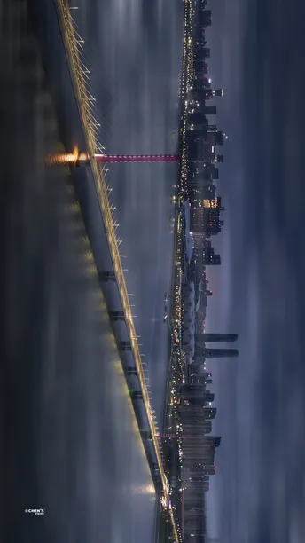 夜晚的悬索桥 城市灯光 摩天大楼在雾中。