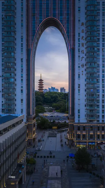 暮色中的城市 高耸的建筑物和一座大型拱门