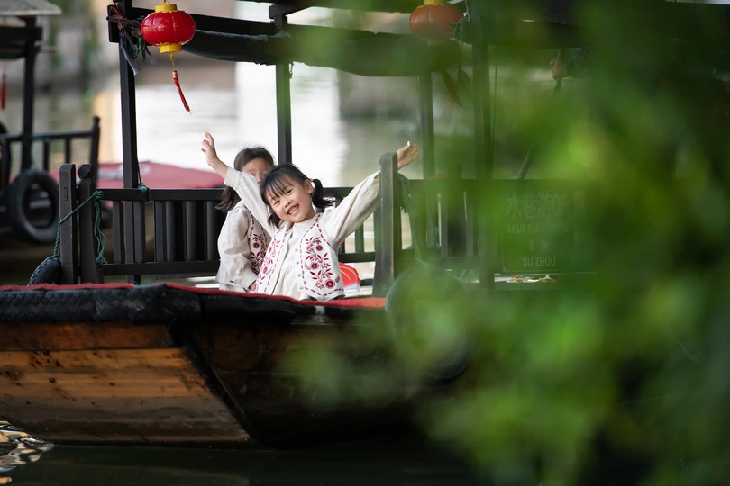 一位年轻女子和一个小女孩在小型船上