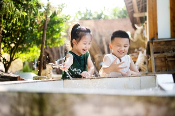 两个年轻的孩子在洗手池里洗手 水从水龙头里流出
