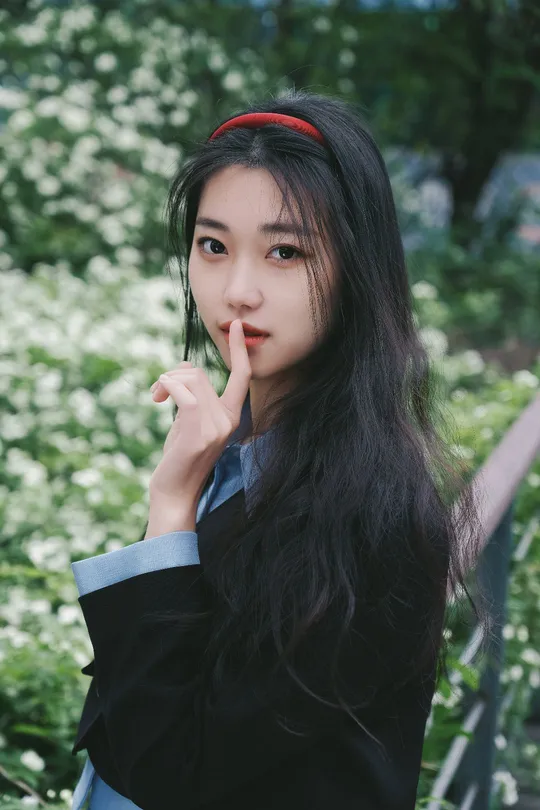 一位黑发女子将手指放在嘴唇上