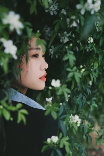 一幅女孩在灌木丛中带着白色花朵的肖像