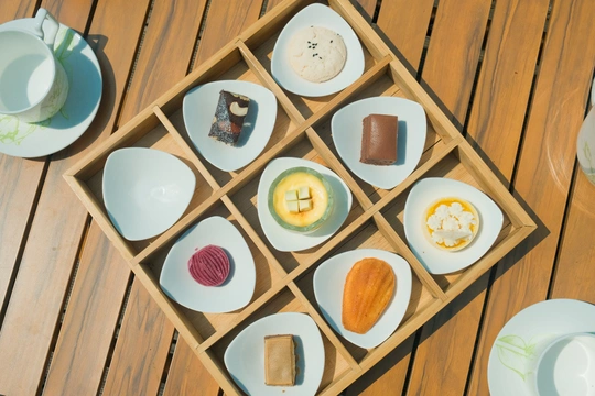 一个小木桌上有小盘子和食物盘子。
