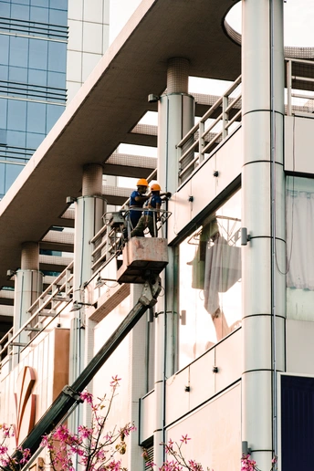一栋高大的办公楼 人们站在窗户外面 一名男子站在建筑物的侧面。