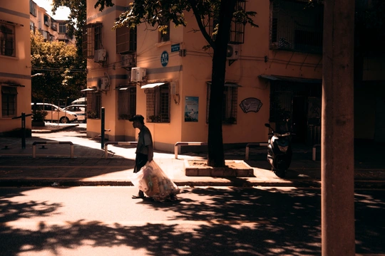 一个人和一个女人穿着黑色衣服走在一条街道上 街道前面有一栋建筑。