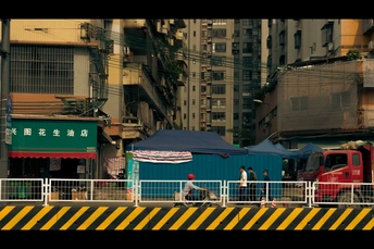 一条街道 有建筑物 一列红色的火车 以及周围行走的人们。