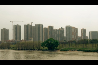 城市前方有一大片水域 周围有高耸的建筑物。