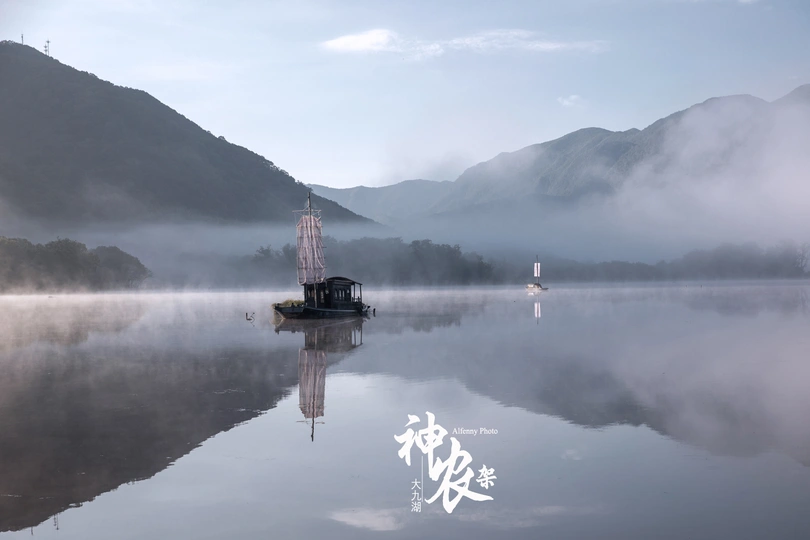 平静的湖面上的小船 背景是薄雾和群山