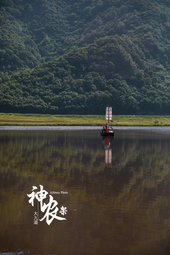 漂浮在群山环绕的大水体上的小船