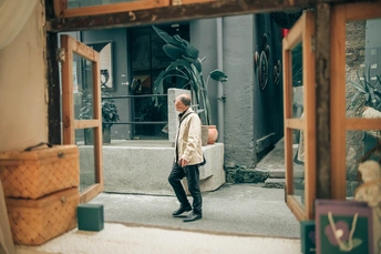 一个在镜子里带着行李箱的男人走在街上