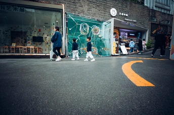一个男子走在街上 孩子们在商店前面的道路上玩耍。