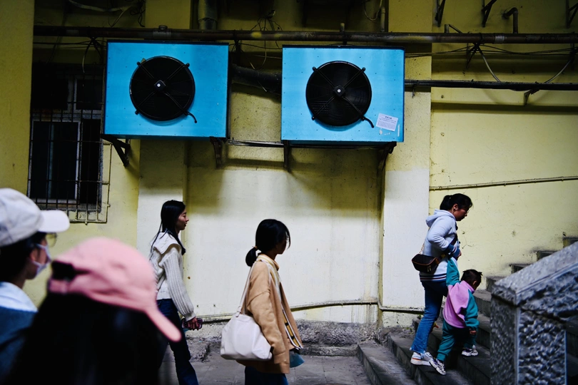 几个人沿着一座建筑附近的一条街道走