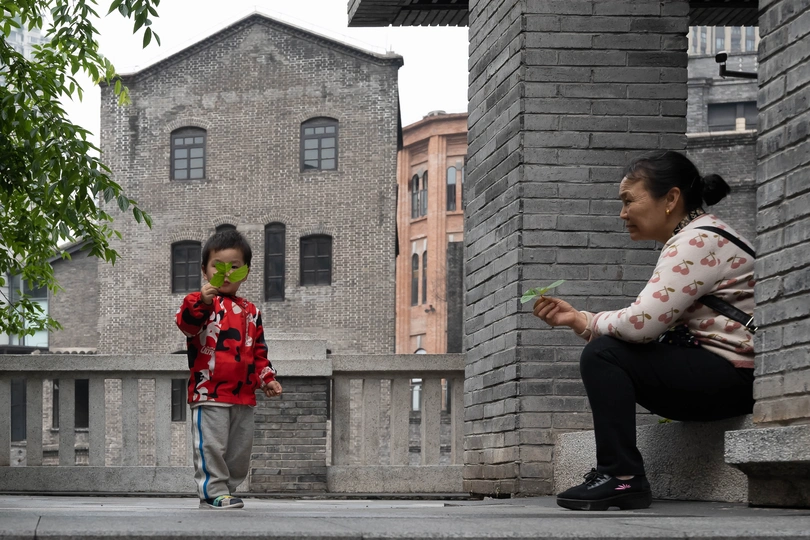 一个戴花的年轻女孩坐在街边一栋建筑前