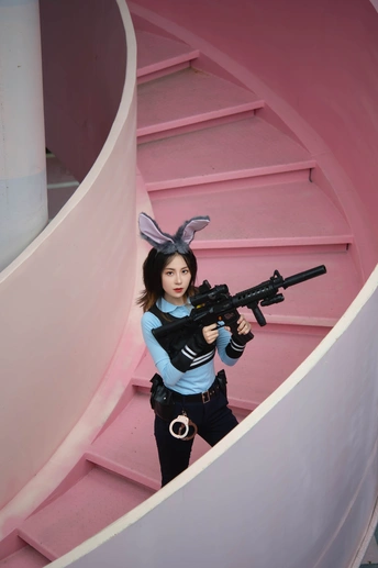 一位穿着服装的女性在楼梯前持枪姿势