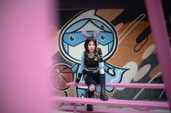 一位年轻女子坐在粉红色长凳上
