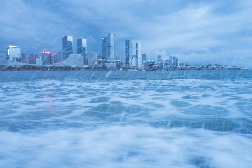 从海洋中的雨中看城市及其天际线 远处的天空和建筑