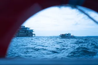 从窗户看到一大片水域 远处有一艘船。