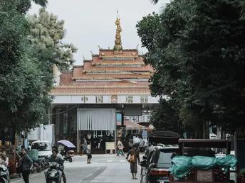 一条街道上有行人、摩托车、汽车和背景中的建筑。