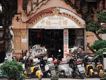 摩托车排成一排 停在建筑物前人行道上的一家商店前 还有几辆摩托车和多辆摩托车停在商店前。