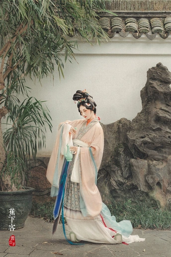 一位穿着和服的女士站在一把雨伞下