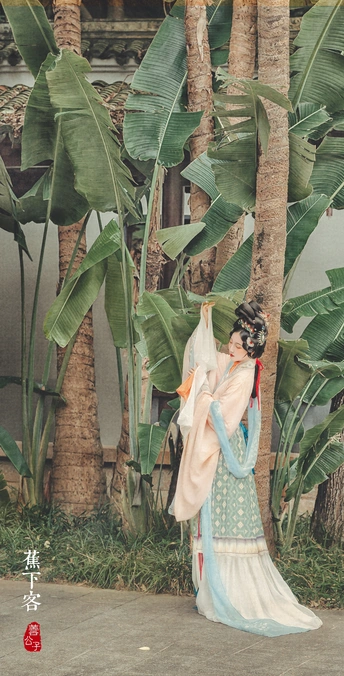 一位穿着裙子的女人雕像站在一丛香蕉树前