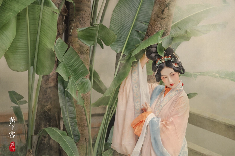 一位穿着和服的女子站在香蕉树下