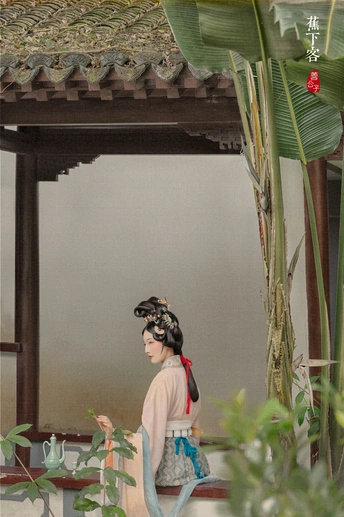 站在镜子前的一个女人 周围有香蕉树和其他植物。