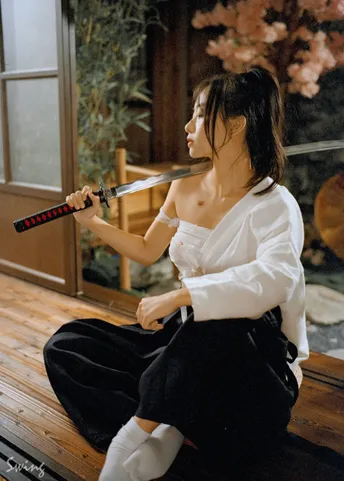 一个坐在门廊木地板上的女人拿着刀