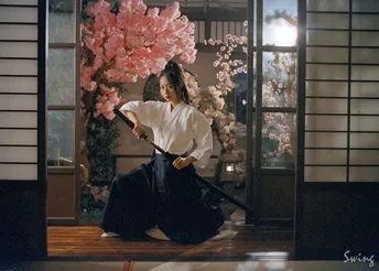 一位跪在樱花树下的穿着白色和服的女人