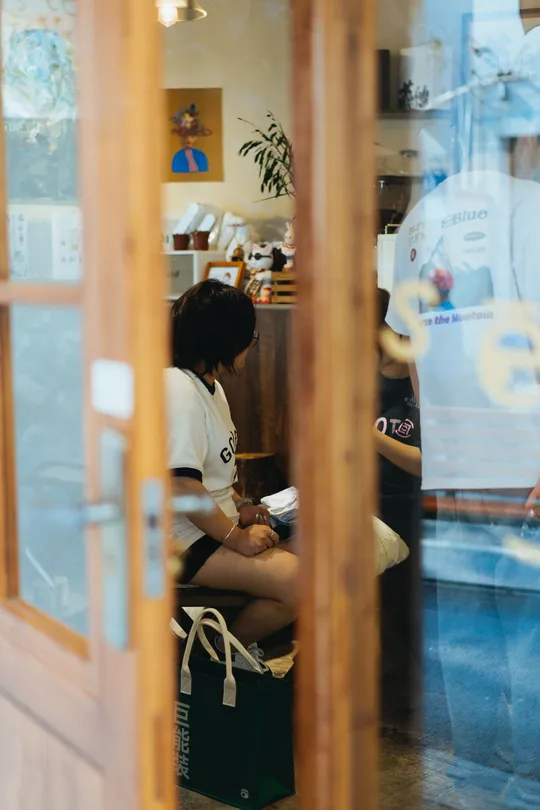 一个年轻人坐在门窗口的镜子里