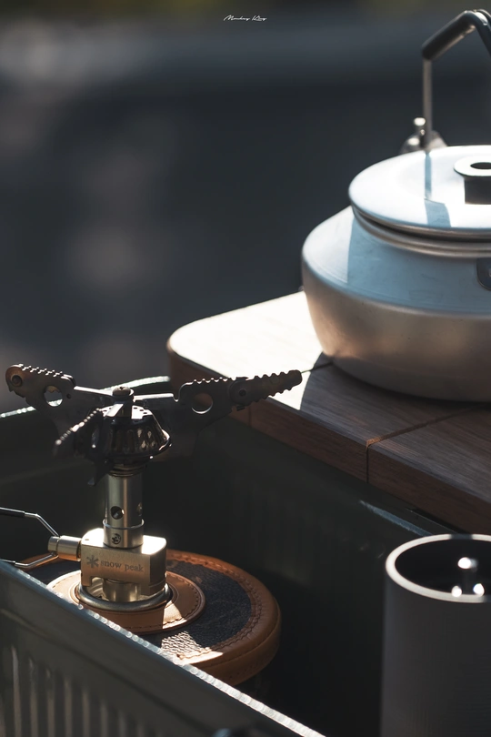 一个带有壶和茶壶的桌子 旁边有一个水槽。