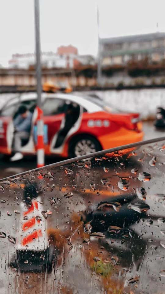 一辆红色汽车在雨水浸透的街道上行驶