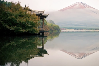 湖中倒影的山的照片 前景中有树木