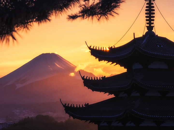 夕阳或日出时 一座寺庙或佛塔轮廓与山峦为背景。