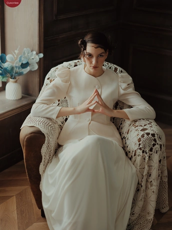 一个美丽的年轻女子穿着一件白色连衣裙坐在一个木制镶板的房间里的一把椅子上