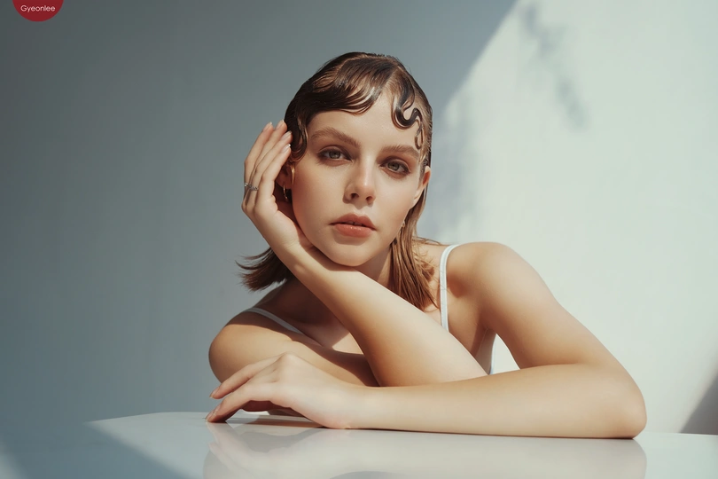 一位年轻美丽的女子坐在白色桌子前的人物肖像