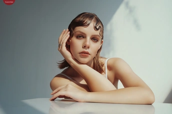 一位年轻美丽的女子坐在白色桌子前的人物肖像