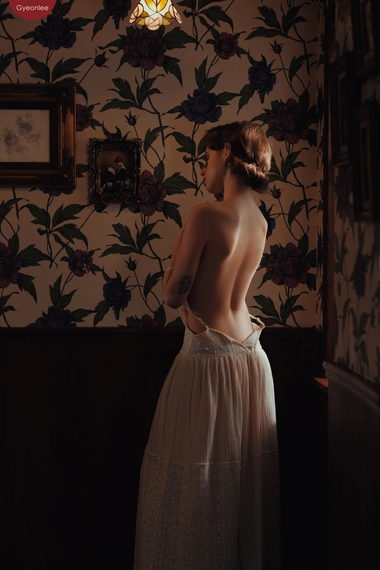 一个穿着连衣裙的女人站在一个黑暗的房间里