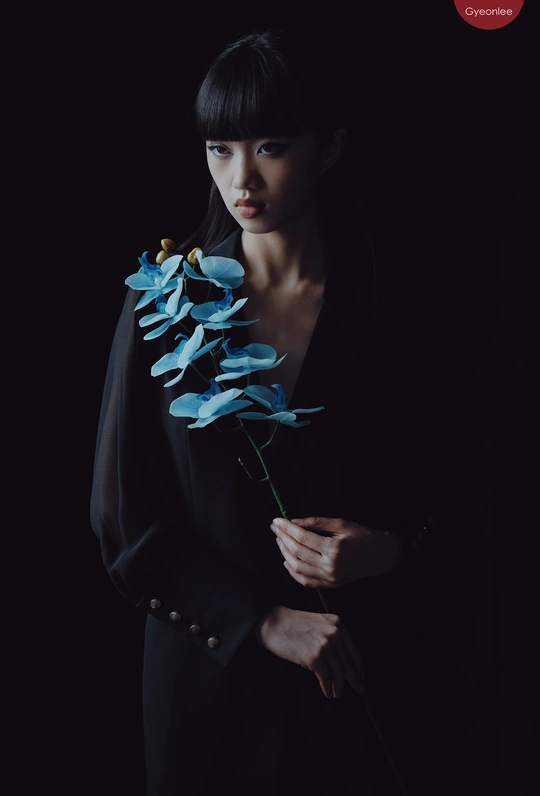 一位年轻女子手里拿着一朵蓝色花