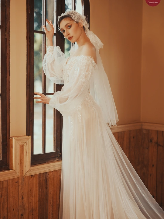 新娘穿着婚纱站在窗户前