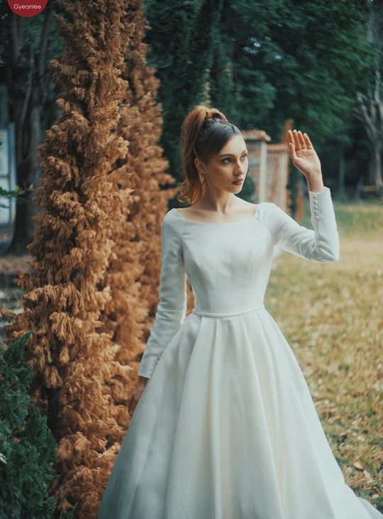 一位穿着白色连衣裙站在田野里的女人