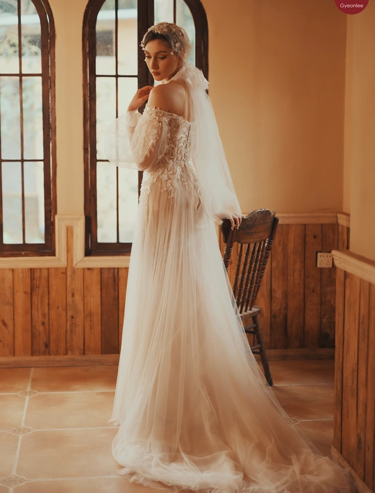 新娘穿着婚纱和头纱站在窗户前