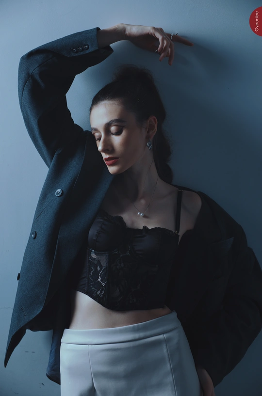 一个穿着黑色上衣和黑色裙子的年轻女子 用手指叉腰姿势拍照