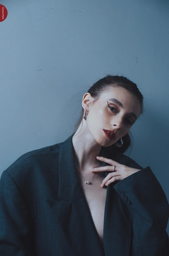 一位穿着黑色口红的模特 背景是蓝色。