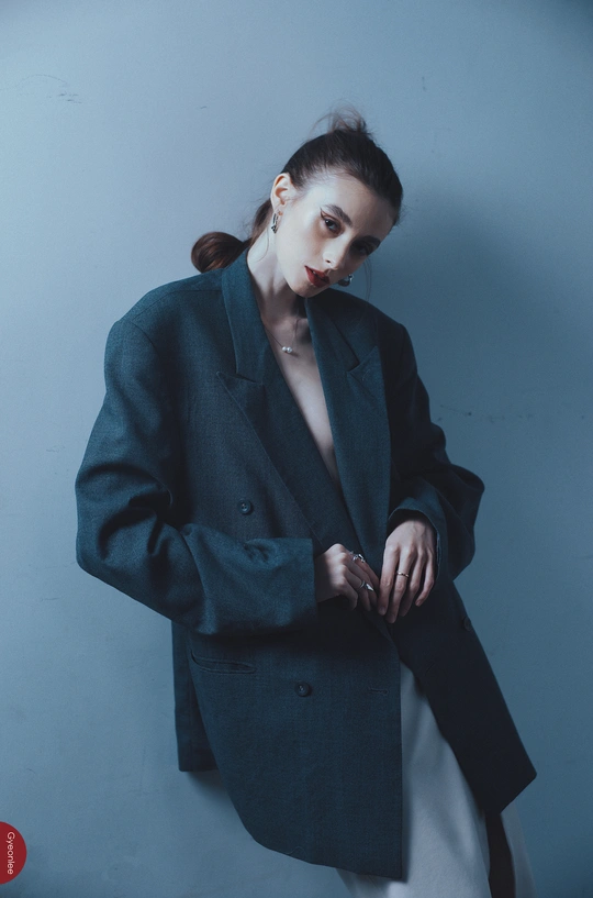 一位穿着蓝色西装的模特站在蓝色背景前