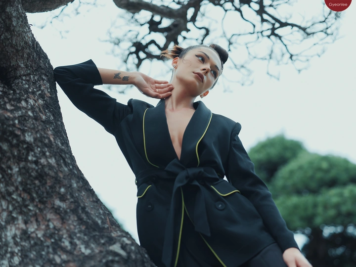 穿着黑色西装的模特儿在树前摆姿势