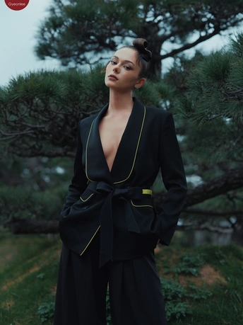 穿着黑色西装的模特站在松树前