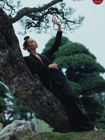 一位女性靠在一棵树上